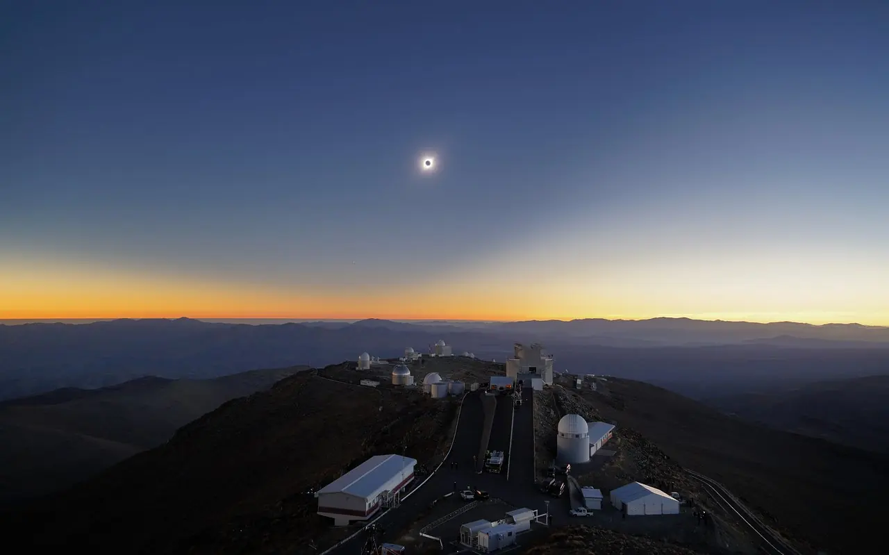 Une eclipse totale de Soleil : la couronne solaire blanche entoure le disque noir de la Lune.