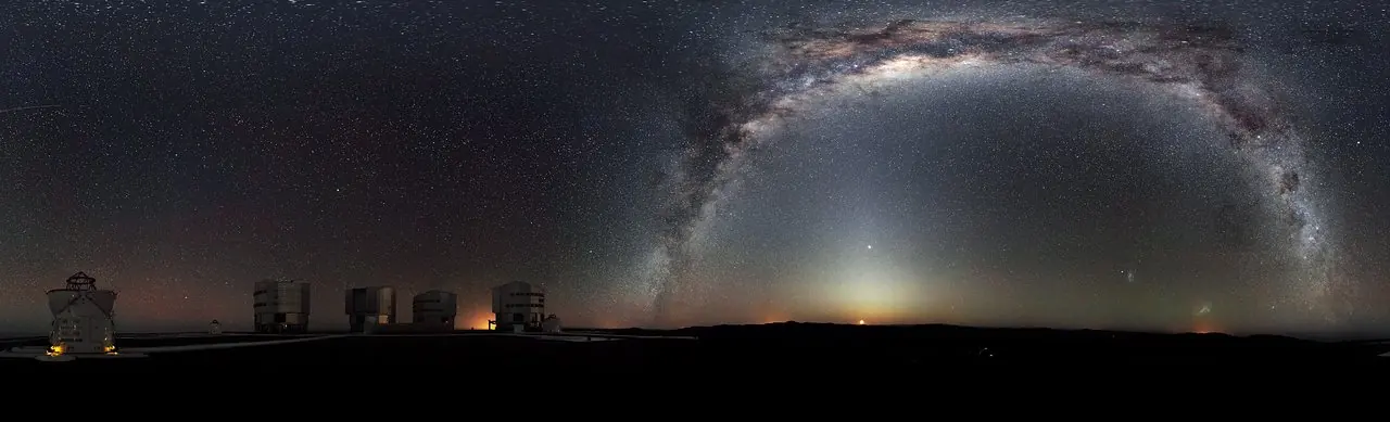 Panorama a 360 degres du ciel austral : la Voie lactee forme une arche entiere au-dessus des coupoles d'un observatoire.