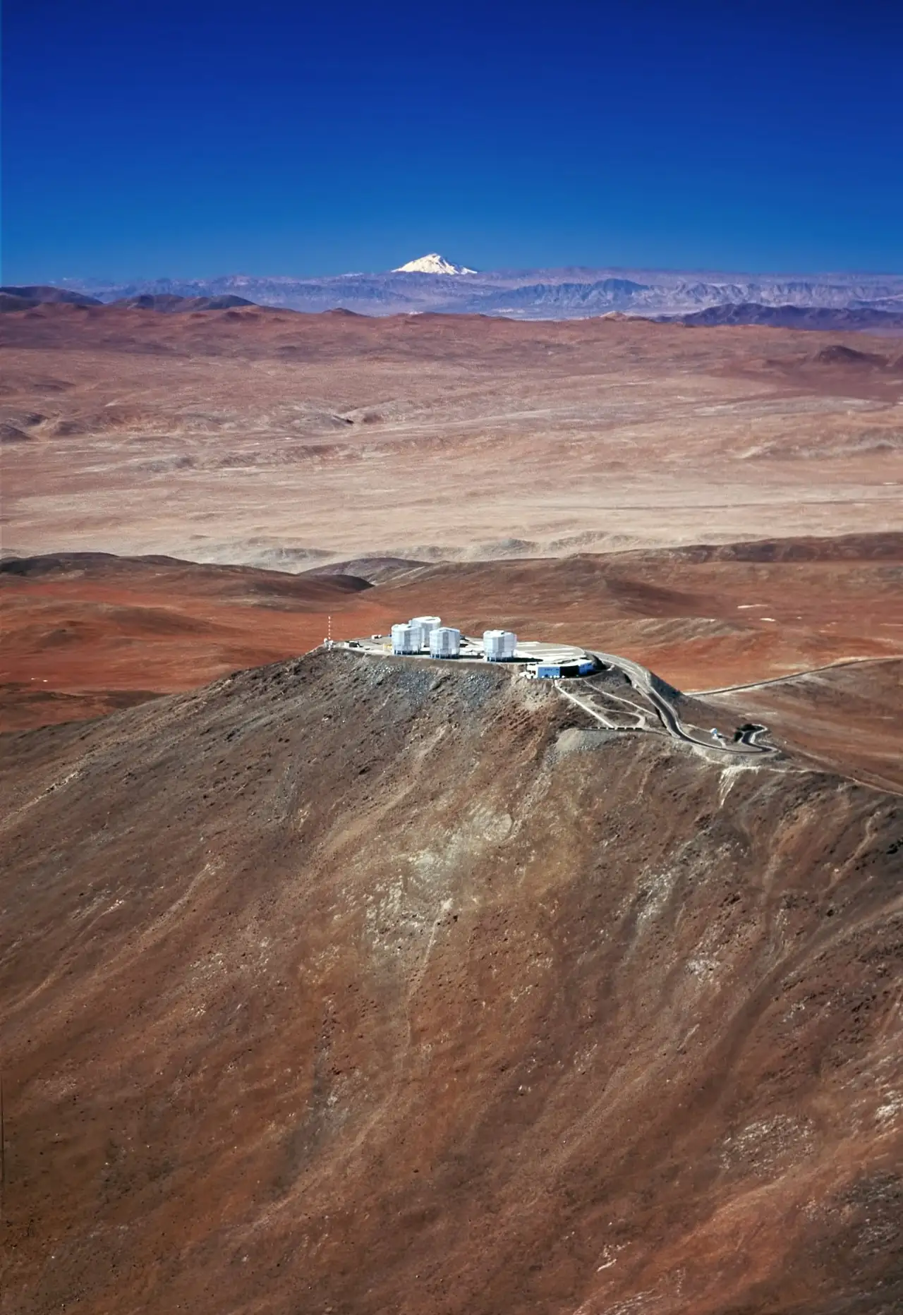Un observatoire isole dans le desert, sans aucune lumiere de ville, avec un volcan a l'horizon.